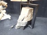 a statue of a hand holding a box with a bunch of wheat