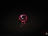 gros plan d'un diamant rose sur une surface noire