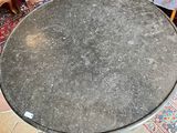 a round table with a black top sitting on a rug