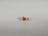 une bague en or avec une pierre rouge au centre
