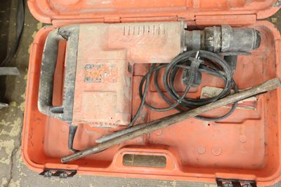 an orange case with tools in it sitting on the floor
