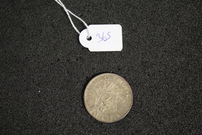 une petite pièce avec une étiquette accrochée à côté d'une autre petite pièce