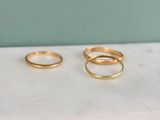 two gold rings sitting on top of a marble counter top