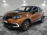 La voiture orange est garée sur un sol à damier dans le garage.