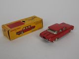 a red toy car next to a yellow box on a white surface