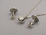 un collier et une paire de boucles d'oreilles en argent posés sur une table