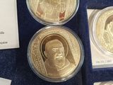 some gold coins are in a display case on a blue surface