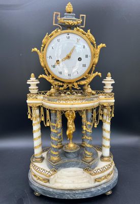 une horloge dorée et blanche posée sur une table