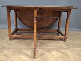 an old wooden table with a glass top on a wooden floor