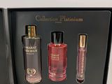two bottles of perfume in a black box on a white surface