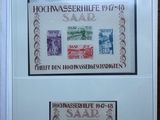 two framed stamps of different countries on display in a glass case
