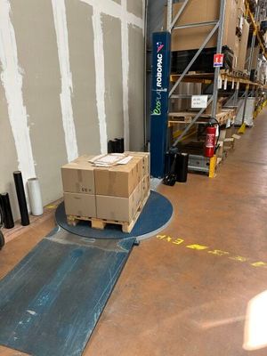 a forklift with a box on the floor in a warehouse
