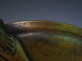 a close up of a bronze plate with a bird on it