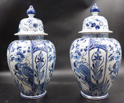 pair of blue and white vases with lids on a black surface