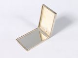 a small mirror sitting on top of a white surface