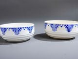 deux bols bleus et blancs ornés de motifs, posés sur une surface grise