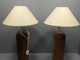 pair of wooden table lamps with white shades on them