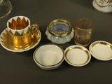 several cups and saucers are sitting on a table next to each other