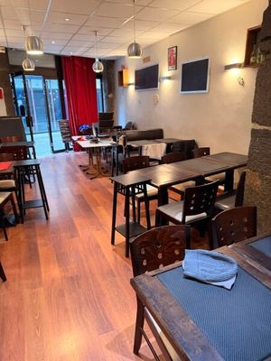 des tables et des chaises dans un restaurant avec des rideaux rouges accrochés au mur