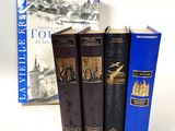 three books sitting on a table next to each other on a white surface
