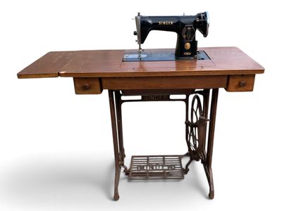 une vieille machine à coudre posée sur une table en bois