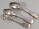 three spoons and a fork on a table