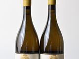 deux bouteilles de vin posées l'une à côté de l'autre sur une table en bois
