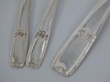 three spoons and a fork are sitting on a table