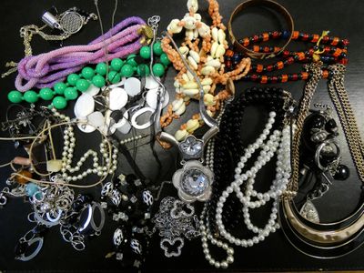 many different necklaces and bracelets laid out on a table