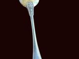 a silver spoon with a spoon handle on a black background