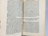 someone is holding a book open on a white surface