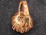 a gold ring with a flower inside of it on a black surface