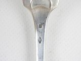 a silver spoon with a heart on it sitting on a table