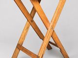 an old wooden folding table with two crossed legs on a white background