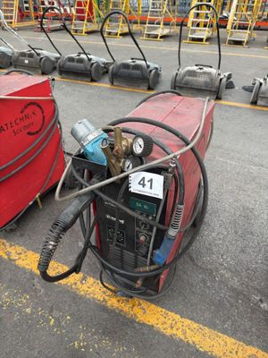 un fût rouge muni d'un tuyau, placé à côté d'autres équipements