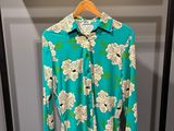 une chemise verte et blanche suspendue à un cintre dans une armoire