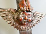 a statue of a bird on top of a wooden pole
