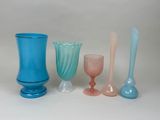 quatre vases en verre de couleurs différentes placés les uns à côté des autres