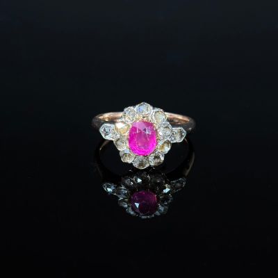 a close up of a pink and white diamond ring on a black surface