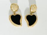 une paire de boucles d'oreilles noires et dorées en forme de cœur sur un fond blanc