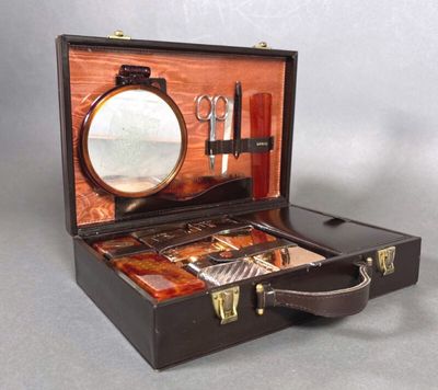 a suitcase with a mirror, scissors, and other items in it