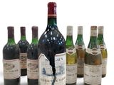 several bottles of wine are lined up in a row on a white surface