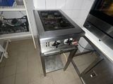 une cuisine équipée d'une cuisinière, d'un four et d'étagères
