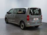grey minivan parked in a large room with white walls