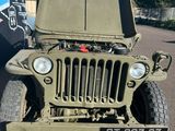 une jeep militaire garée sur un parking à côté d'un immeuble