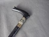 a black and gold cane with a black handle