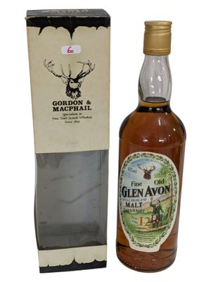 une vieille bouteille de whisky de malt Glen Avon posée devant une boîte en carton