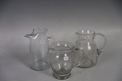 trois pichets en verre et une carafe en verre posés sur une table