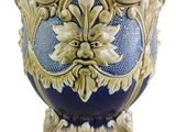 a blue and gold vase with a face on it
