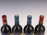 three bottles of wine are lined up in a row on a white surface
